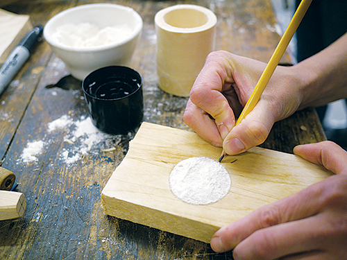 Trace around the flour that is left after flipping a flour-filled box onto a dampened piece of wood that will serve as the box lid.