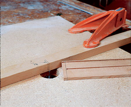 Transfer the bit’s center line and outside cutting edge to the fence, then use the lines as starting and stopping points when routing the stopped grooves.