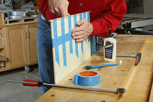 Rip overly wide wood strips for capping the ends of the top panel, and glue and tape them in place.