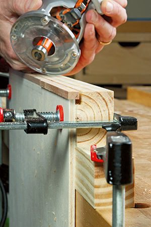 The author clamped the workpiece against a long, notched scrap to add stability for the router base.