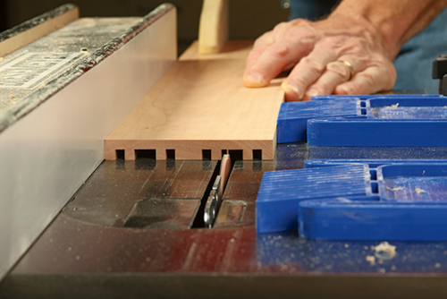 A standard ripping blade can mill both the narrow panel grooves and the wider tray grooves in the doubled-up blank.
