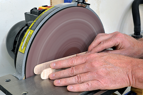 Bevel the outside tips of the tongs on a disc sander, then smooth the bevels with a sanding block.