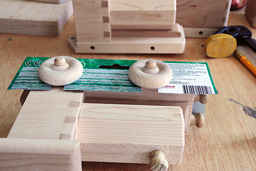 Cardboard, slotted to fit around the axles, serves as a spacer to prevent them from being glued too deeply into the bases and binding the wheels.