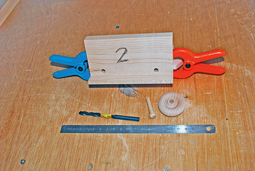 A second drilling jig ensures that the axle holes will be placed accurately on the sides of the train car bases — both lengthwise and, even more importantly, through their thickness.