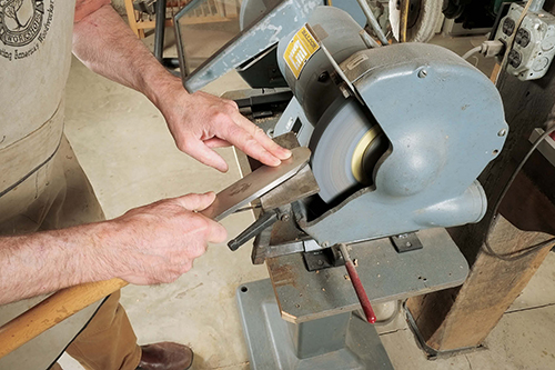 Grinding is the easiest way to raise a burr. With a grinding rest set at 15 ˚ to 25˚, start moving the scraper edge as soon as it touches the wheel.