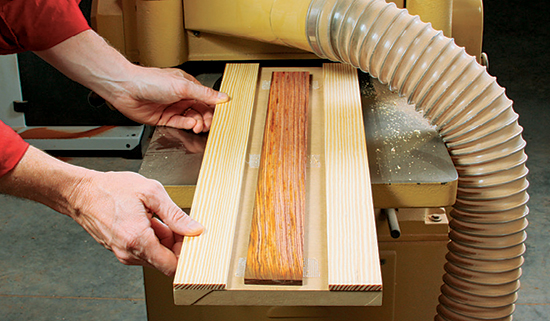 Resaw and plane down a piece of attractive stock for the two knife scales. Tape it to a carrier board to keep the wood flat as it gets thinner.