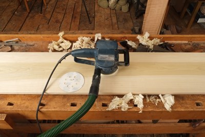 Small jumps in grit size are critical. If you jump more than two sizes, you will not cut away the scratch marks from the last grit and end up with a mostly shiny surface with little scratch marks throughout. Here, I went from 80 to 180, and you can see the result in the third photo. The darker area along the center of the board reveals a coarser scratch pattern from the 80-grit paper that the finer 180-grit abrasive can't remove.