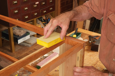 Using a padded block which secures the paper helps greatly with hand sanding. Many companies sell sandpaper already glued to a piece of high density foam. Make the final strokes as parallel to the grain as possible.