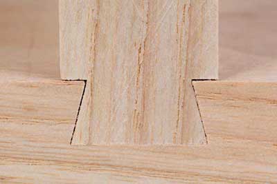 The inward-slanting walls of the dovetail groove prevent the tail from pulling straight out. To assemble the joint, you slide the tail into the groove from the end.