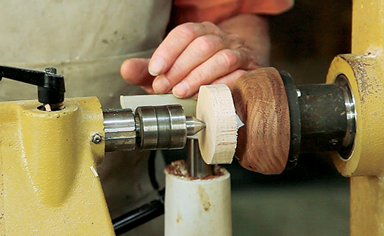 Photo 2: Pin a yo-yo blank to the chuck with a tailstock center, pressing the blank firmly against the chuck.