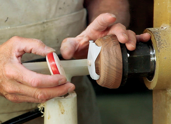 Photo 5: Reverse-chuck each yo-yo disc on a dowel drilled into the chuck. Hold the disc in place with tape.