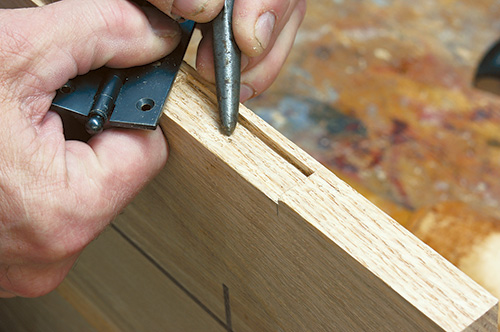 Checking screw hole marking on entertainment center door