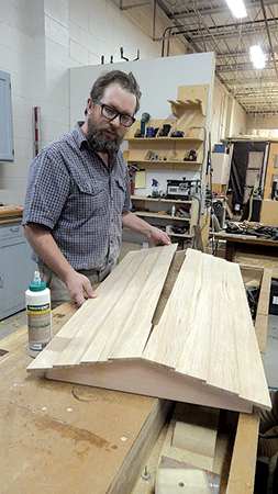 Arrange the roof panels for an even overhang on the roof frame. Mount them to the frame with glue and finish nails. Putty over the nail holes, if you like, to fill and hide them.