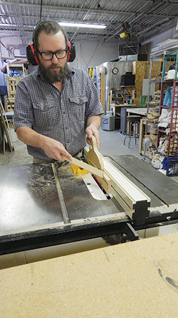 Cut the V-shaped angles into the roof ends at the table saw with the blade tilted to 75°. Make these two cuts incrementally, raising the blade until the inner waste piece falls free.