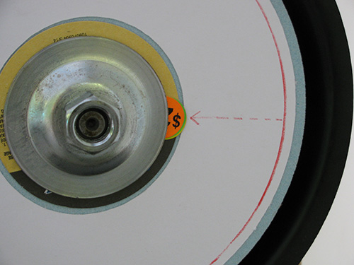 Sticker shim placed at interior of grinding wheel