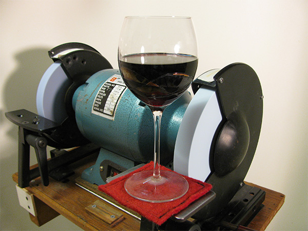 Bench grinder holding up a glass of wine