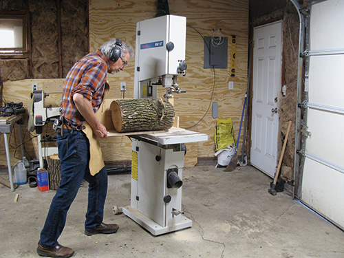 Sawing a log into pieces at a band saw