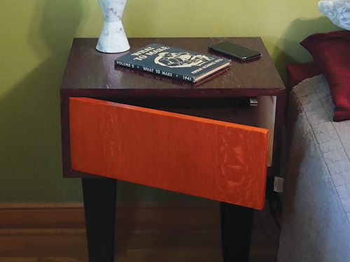 Cordless charging bedside table with swinging door