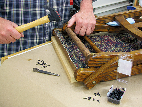 Attaching seat fabric to folding chair with tacks