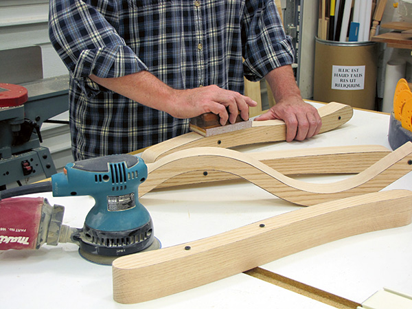 Smoothing chair parts with hand sander