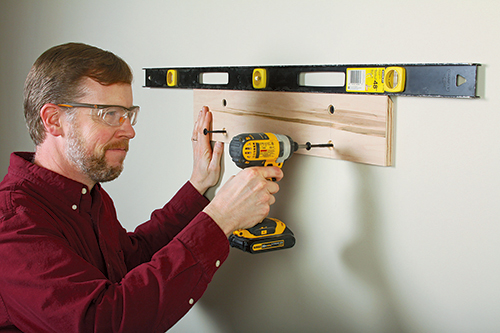 Level and fasten the wall cleats to two wall studs, with four heavy-duty screws.