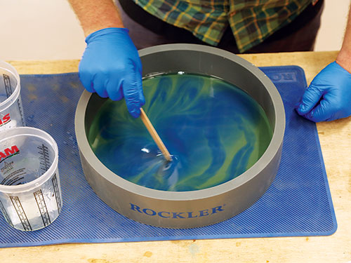 Stirring green and blue epoxies together to create patterns
