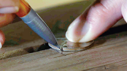 Using a coin to mark out cuts for stretchers