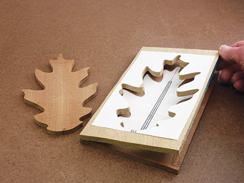 Cutting out a pattern of a leaf to create a place for an inlay