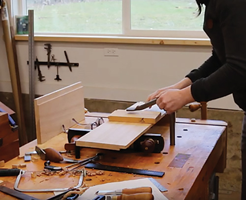 Clamping down pin board and tail board to finish dovetail cut on whiskey cabinet