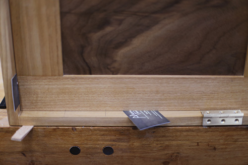 Spacing door with cards before hinge installation in whiskey cabinet