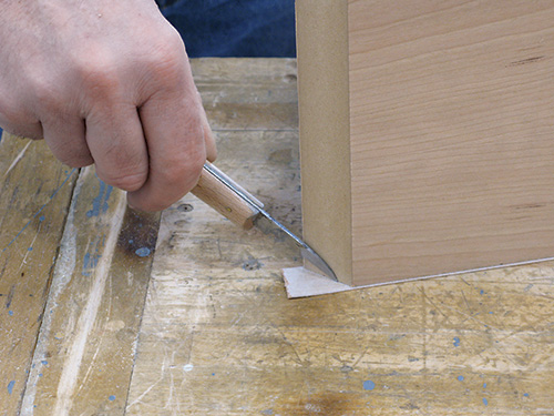 Using knife to trim veneer tape