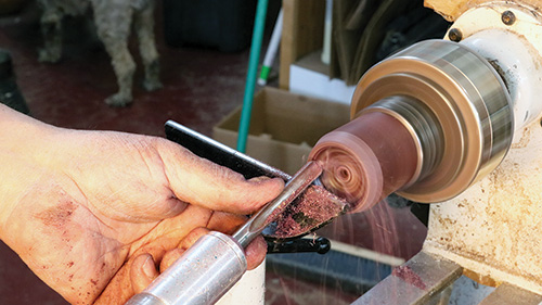 Using a bowl gouge to cut recess into spinning top base