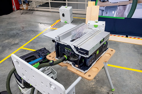 Festool cordless saw set up on stand and connected to dust collector