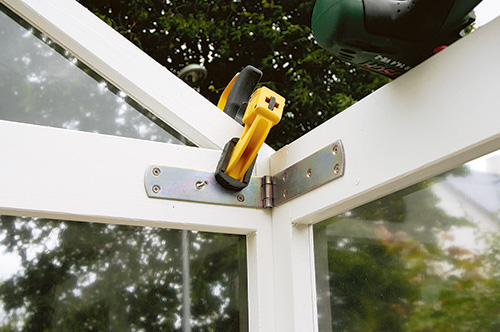 Clamping hinges into place on fold-up greenhouse frame