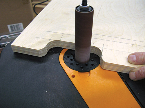 Sanding edges of folding shop desk handle with a spindle sander