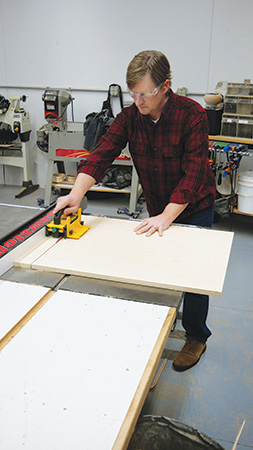 Cutting out plywood panels on a table saw for folding desk