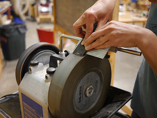 Guiding planer blade on grinding wheel