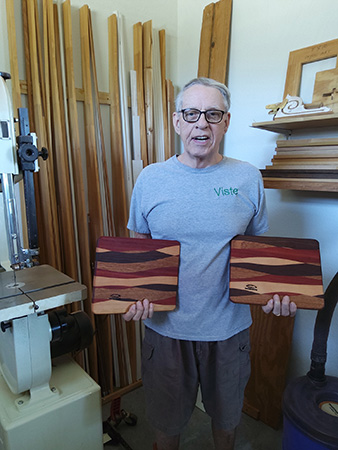Don Van Houtte holding four wood cutting boards