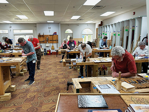 Greenville Woodworker's Guild members working at workbenches