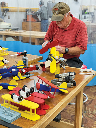 Greenville Woodworker's Guild member assembling toy airplains