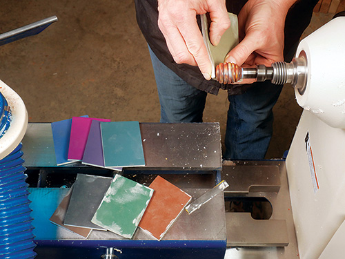 Sanding down honey dipper handle with abrasive pads