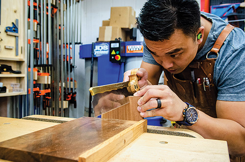 Huy Huynh hand cutting dovetails with a saw