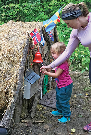 Child leaving donation at elf house display