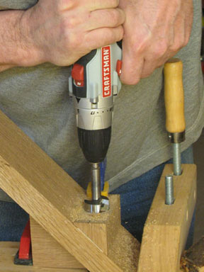 Figure 2: Bore a 1-1/4"-diameter hole through the center of the upright and parallel to the bottom edge. If you do this with a handheld drill, secure a drilling guide made of scrap to the upright first to help start and guide the Forstner bit.