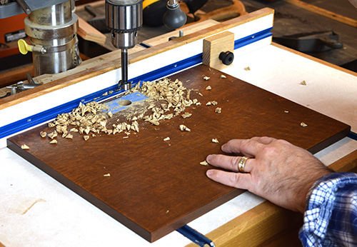 Cutting cam lock hole in hutch door with drill press