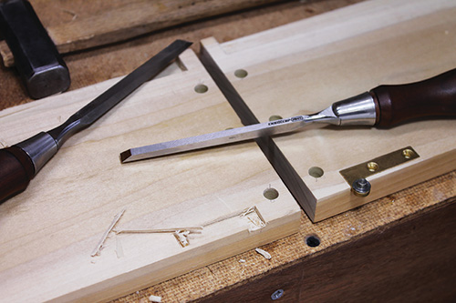 Using a chisel to cut out mortises