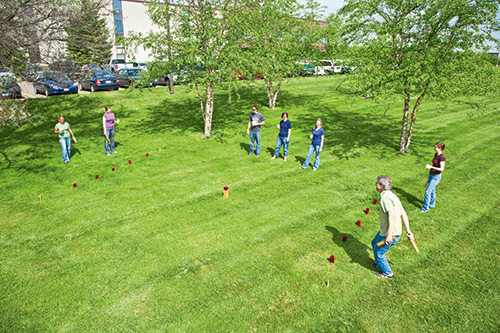 Rob playing kubb game outside on the lawn