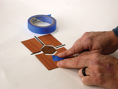 Taping pieces of engraved box veneer