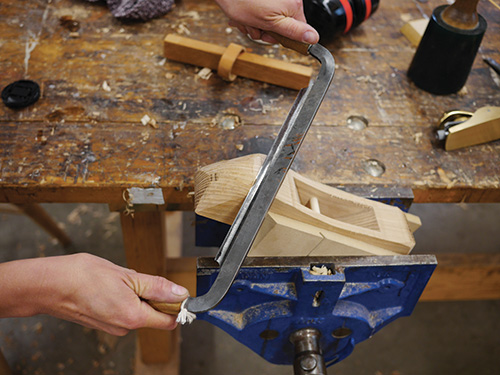 Removing excess wood from hand plane body with a draw knife