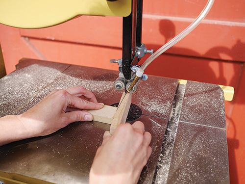 Cutting wooden hand plane wedge with a band saw.